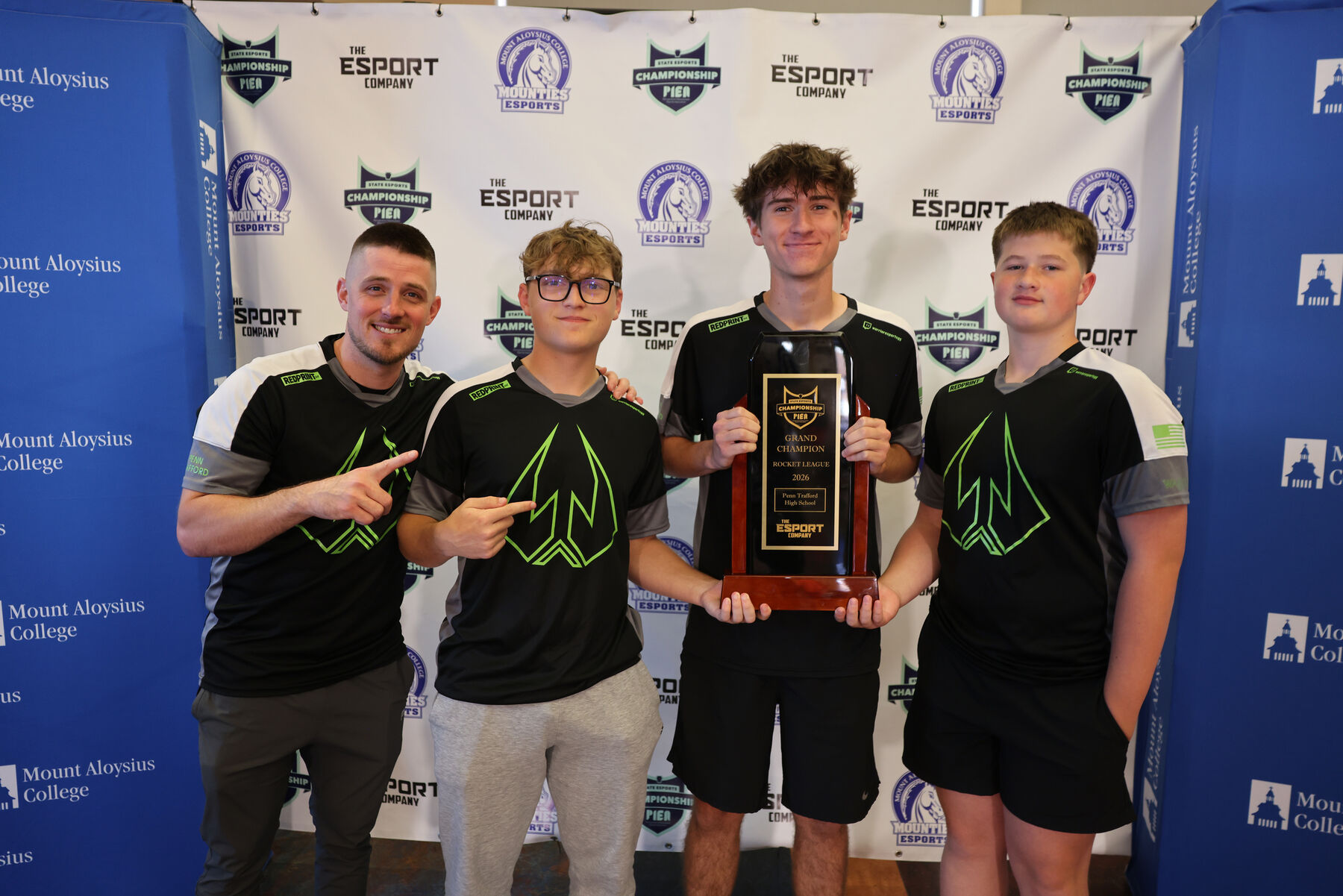 A PIEA state championship team holding their trophy at the PIEA backdrop